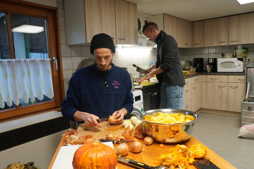 Zwei Personen arbeiten in einer Küche.