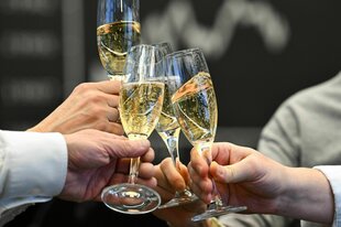 Männerhände halten Sektgläser in der Hand und stoßen an