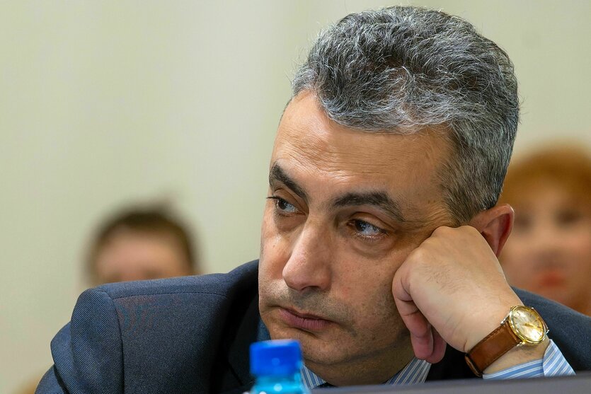 Ein Mann stütz seinen Kopf auf seine linke Hand