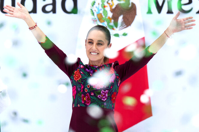 Claudia Sheinbaum steht mit gestreckten Armen und einem Lächeln im Konfettiregen