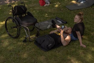 Zwei Personen chillen auf einer Wiese