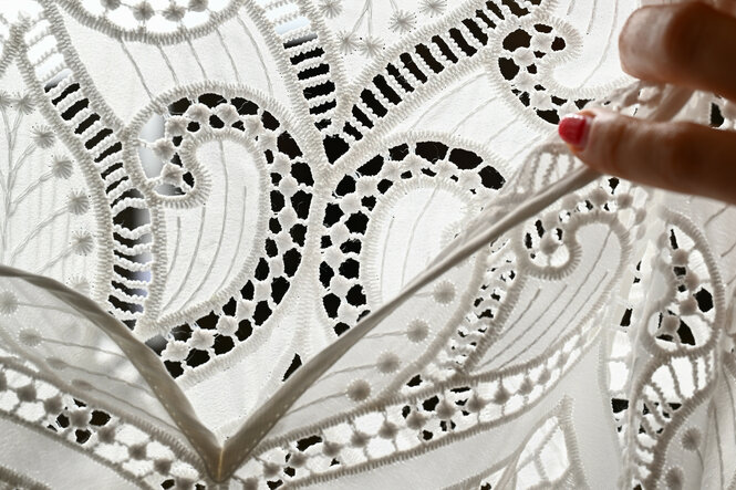 Ornamente aus Spitze sind an einem Dirndl angebracht