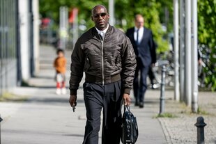 Joa Chialo mit Sonnenbrile und Aktentasche