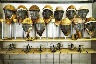 Helme und Säbel zum Fechten in einem Regal aufbewahrt