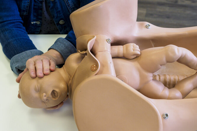 Demonstration einer Geburt an einem Modell.