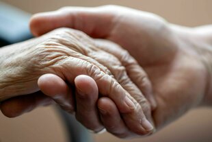 Eine Hand hält eine andere ältere Hand fest