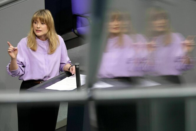 Clara Bünger spricht am Rednerpult und hebt den Zeigefinger