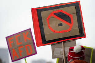 Ein Teilnehmer hält bei der Demonstration eines Bündnisses "Wir sind die Brandmauer" für Demokratie und gegen Rechtsextremismus ein Plakat mit der Aufschrift "FCK AFD".