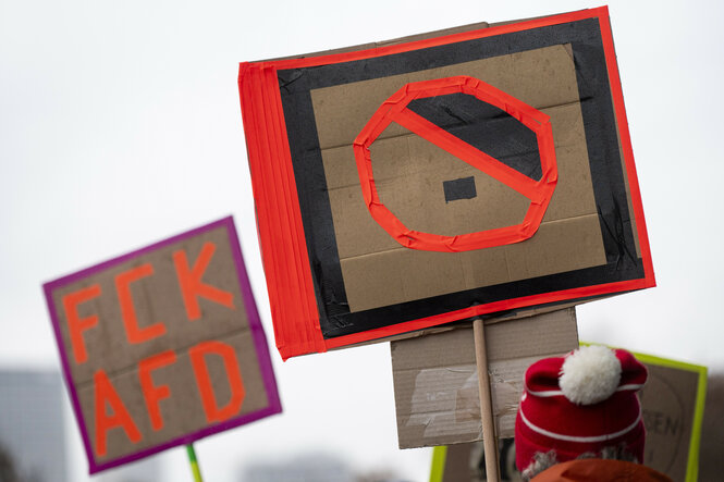 Ein Teilnehmer hält bei der Demonstration eines Bündnisses "Wir sind die Brandmauer" für Demokratie und gegen Rechtsextremismus ein Plakat mit der Aufschrift "FCK AFD".