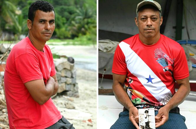 Humberto Almeida sitzt am Strand in einem roten T- Shirt - Evaldo Pereira trägt auch ein rotes Shirt, eine Basecap und hält ein Kinderfoto in die Kamera