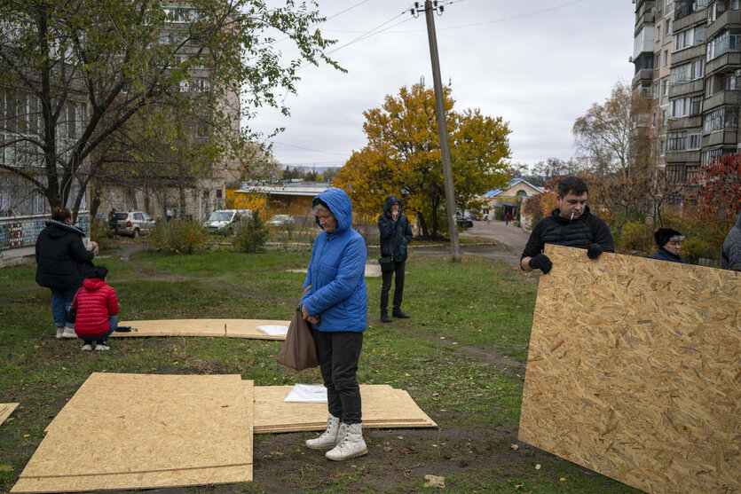 Menschen mit Holzplatten zwischen Wohnhäusern.
