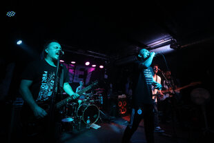 Grünlich angeleuchtete Musiker auf einer Bühne