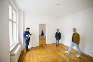 Mehrere Personen in einer leeren Wohnung.