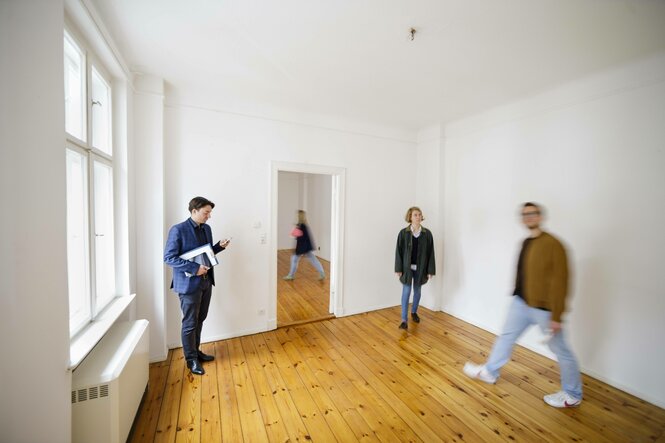 Mehrere Personen in einer leeren Wohnung.