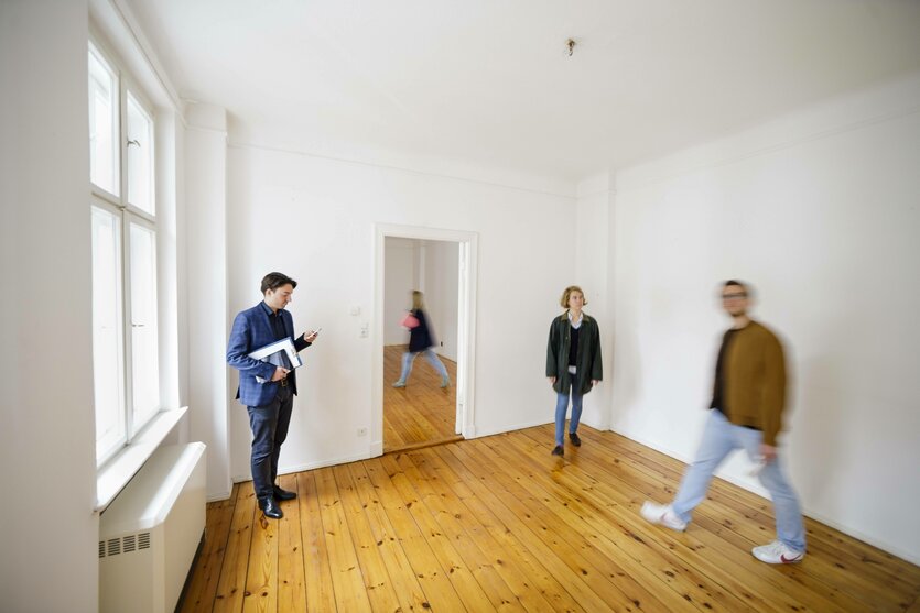 Mehrere Personen in einer leeren Wohnung.
