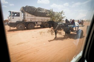 Fahrzeuge auf einer sandigen Pist.