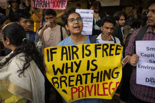 Frau mit Protestplakat: Wenn die Luft frei ist, warum ist Atmen dann privat?