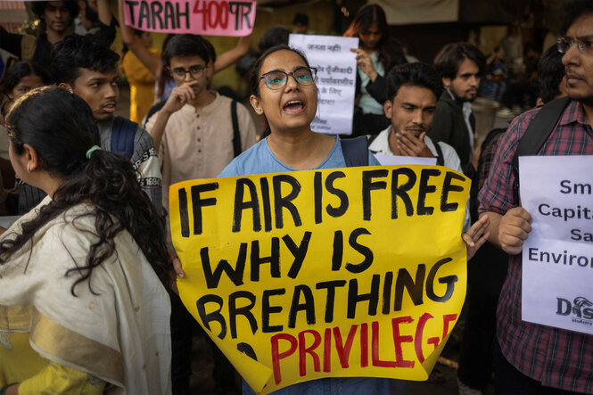 Frau mit Protestplakat: Wenn die Luft frei ist, warum ist Atmen dann privat?