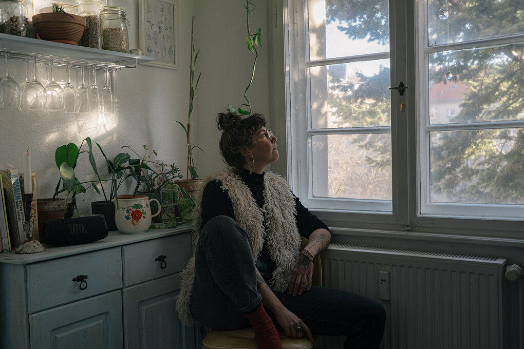 Ein Frau schaut aus ihrem Küchenfenster