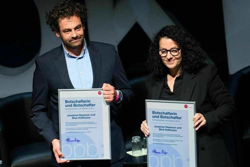 Shai Hoffmann und Jouanna Hassouns halten Urkunden