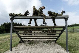 Soldaten klettern auf einer Hindernisbahn