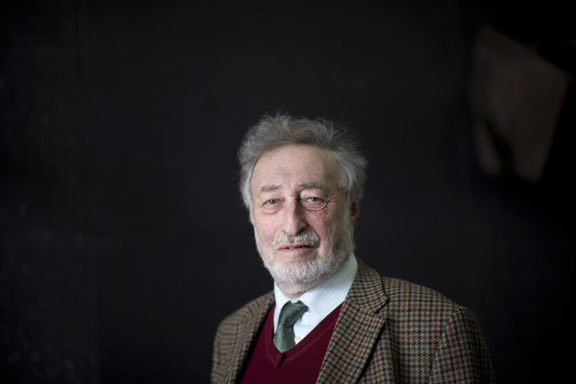 Porträt von Micha Brumlik, er trägt Tweed-Jacket, Hemd, Krawatte und einen weinroten Pullunder