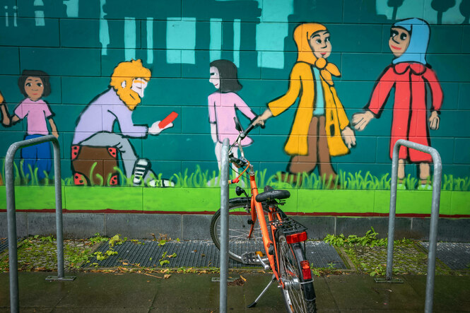 Ein Graffit zeigt Menschen an der Wand des LEA