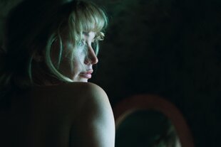 Einer junge blonden Frau mit kurzem Bob-Haarschnitt und Pony blickt zur Seite