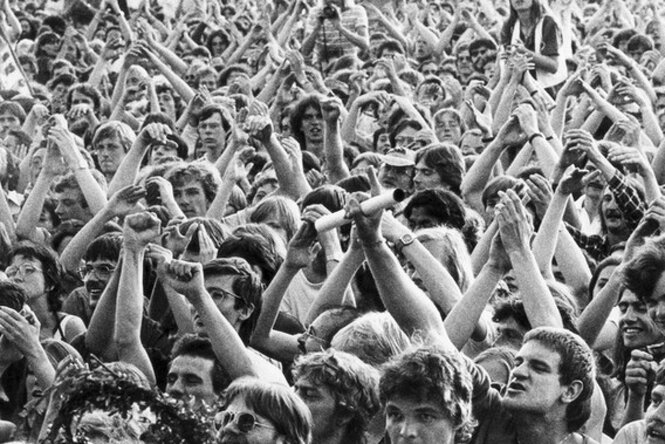 Eine Menschenmenge mit den Händen zum Himmel