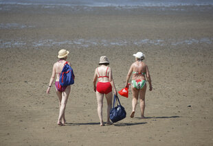 Drei ältere Damen gehen bei Ebbe am Strand