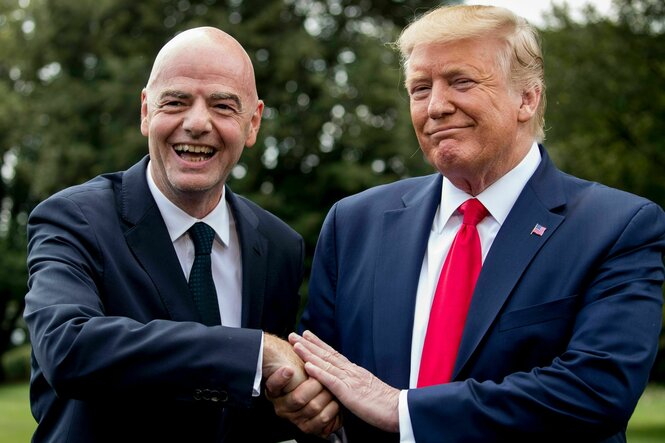 Trump hält die rechte Hand von Infantino mit seinen beiden Händen