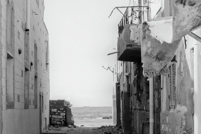 Blick durch eine Gasse zwischen Häusern aufs Meer