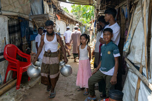 Menschen zwischen temporären Hütten.