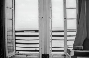 Blick durch zwei geöffnete Fenster aufs Meer