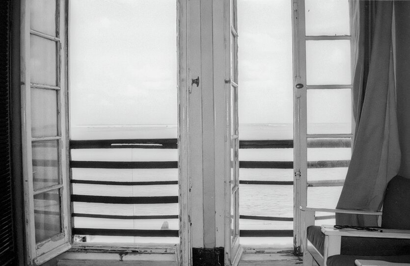 Blick durch zwei geöffnete Fenster aufs Meer