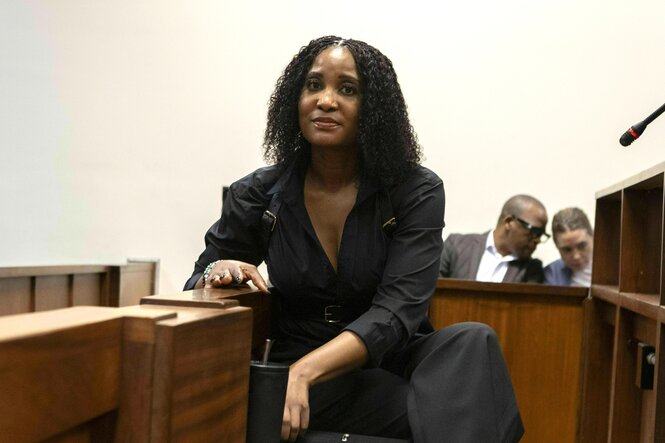 Duduzile Zuma-Sambudla sitzt im Gericht und schaut sehr selbstbewusst in die Kamera, sie trägt einen schwarzen Hosenanzug