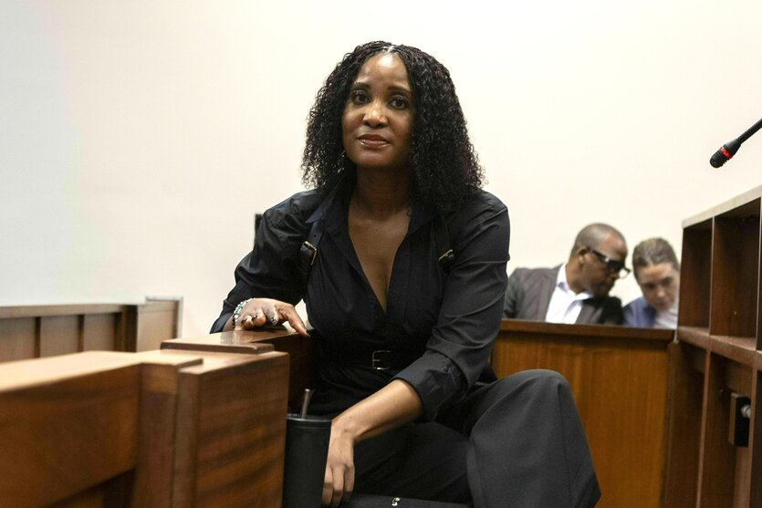 Duduzile Zuma-Sambudla sitzt im Gericht und schaut sehr selbstbewusst in die Kamera, sie trägt einen schwarzen Hosenanzug