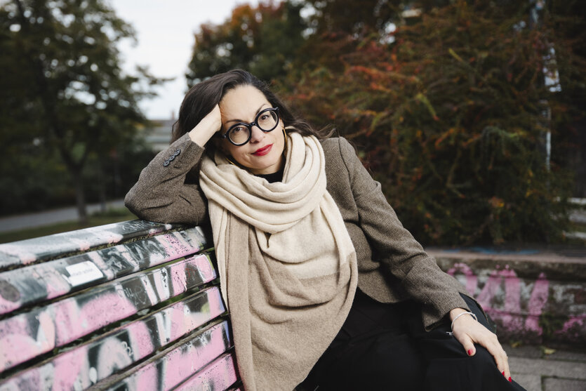 Marina Chervinsky sitzt auf einer Parkbank in Berlin