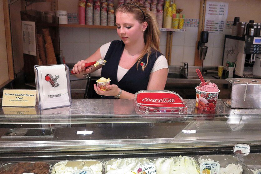 Eine Person hinter der theke eines Eisladens.
