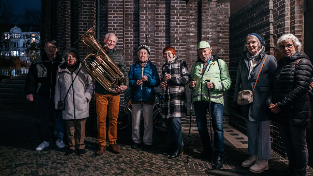 Eine Menschengruppe vor einer Kirchenmauer
