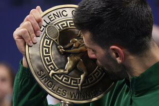 Novak Đoković küsst eine Trophäe mit griechisch inspirierter Verzierung