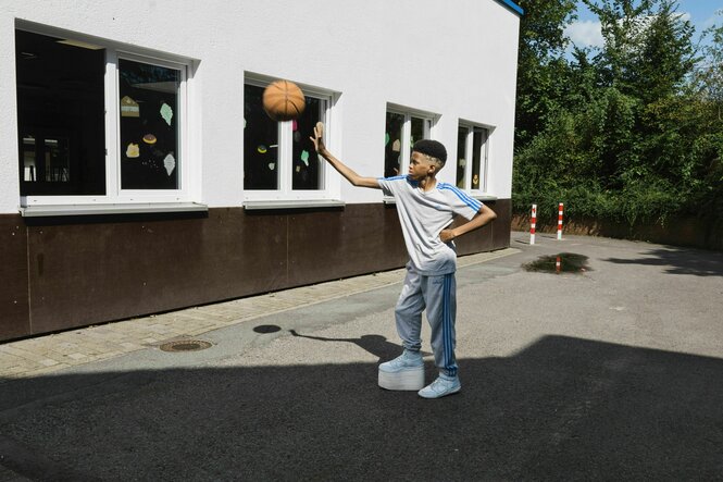 Ein Kind spielt mit eine Basketball.