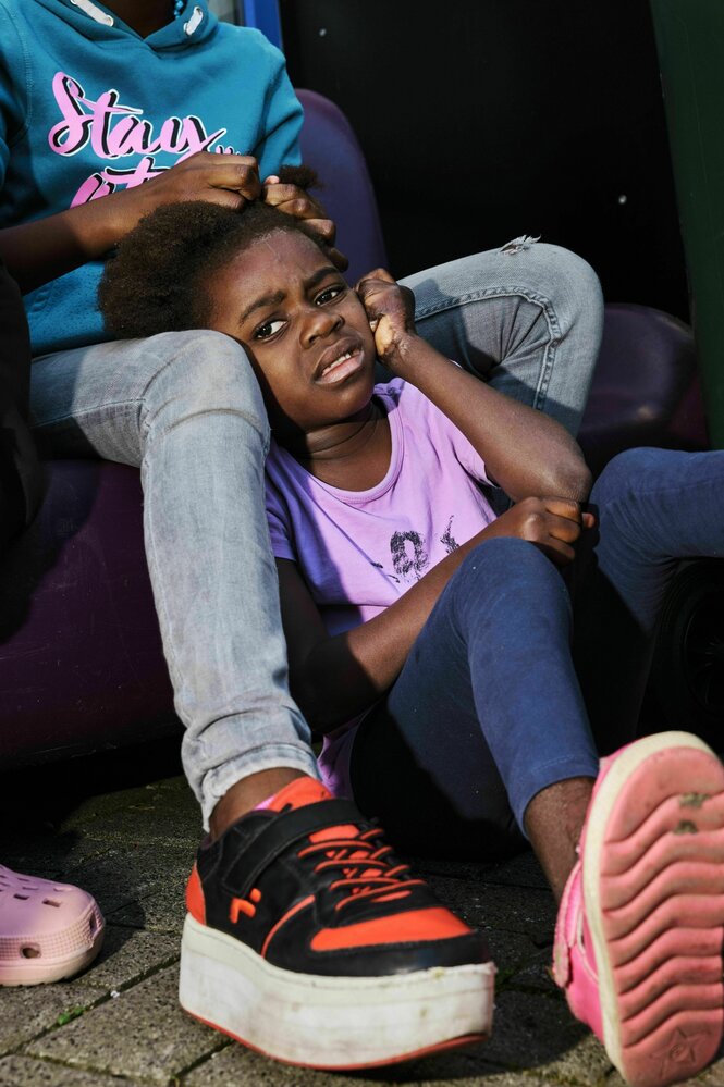 Zwei Kinder aneinandergelehnt.