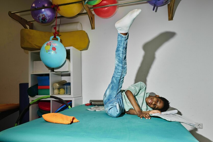 Ein Kind turnt auf einer Liege herum.