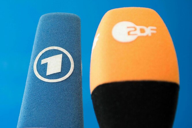 Zwei Mikrofone mit den Logos von ARD und ZDF.