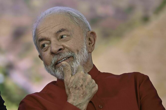 Ein Mann mit rotem Hemd schaut zur Seite und lächelt