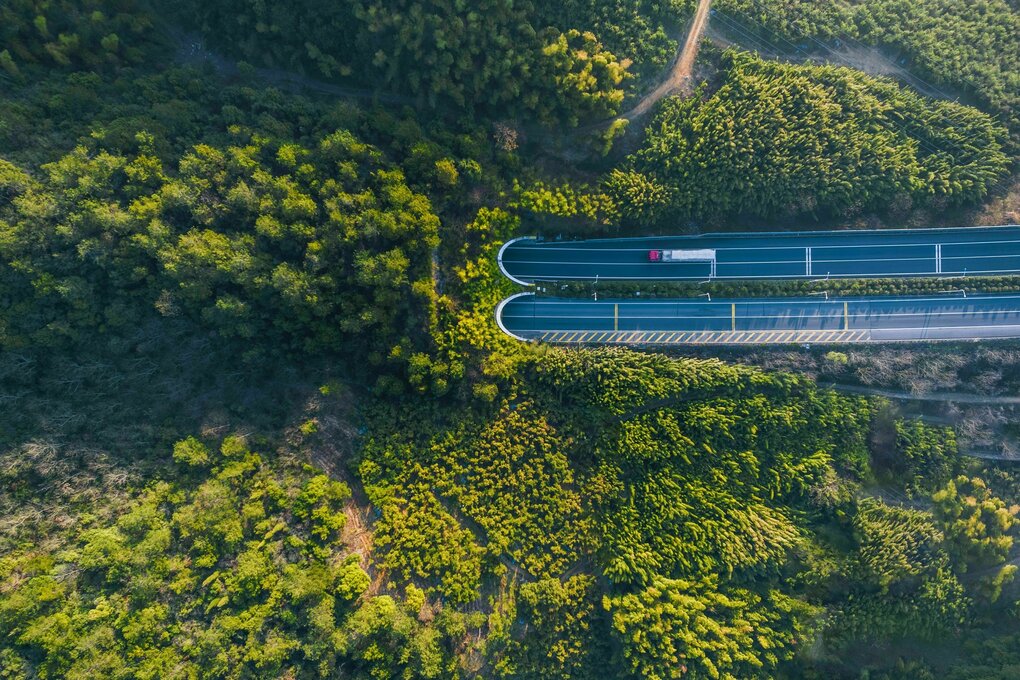 Hochwinkelaufnahme von einem Lastwagen, der sich auf einen Autobahntunnel zu bewegt
