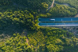 Hochwinkelaufnahme von einem Lastwagen, der sich auf einen Autobahntunnel zu bewegt