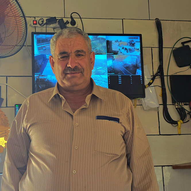 Jihad Nawaja steht vor dem Bildschirm, auf denen die Aufnahmen seiner Überwachungskameras zu sehen sind