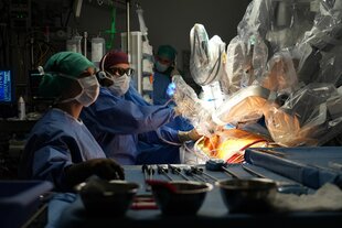 Medizinische Fachkräfte operieren am Herzen eines Patienten mit dem ersten OP-Roboter